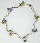 Wavy strip forming fashion bracelet with blue yellow color beads embedded