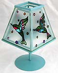 Blue table lamp style candle holder with painted bird figure on the cover