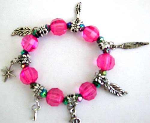 Jewelry with animal motifs. Dark pink color facet beads and silver beaded fashion charm stretchy bracelet with assorted design figure, leaf, cross, triangle, key and dollar sign