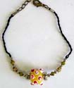 Black string fashion anklet with spiky yellow eye and star beads in center
