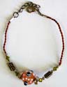 Red string fashion anklet with spiky orange eye bead and retangular flower beads in center