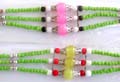 Tibetan fashion beaded bracelet with triple green beaded strings holding 3 mini red, white and large silver capped pink / yellow color beads at center