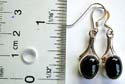 Fish hook sterling silver earring in carved-out Y shape pattern design holding an oval shape black onyx stone 