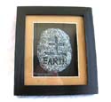Black wooden edge glass frame fashion wall plaque holding a stone with carved-in Chinese character "EARTH" set in middle 