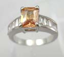 Cz ring in light orange color set in centre and five mini clear cz beside, plated with rhodium in brass bass