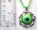 Fashion necklace in triple color string design with a green rounded evil eye pattern central decor, spiral metal pendant at center