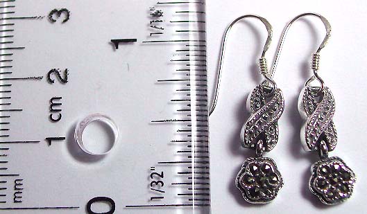 Sterling silver earring with dotted X shape pattern holding a marcasite stones embedded flower pattern