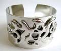 Fashion bangle in plain wide band design with tattoo pattern decor at center