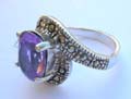 Central open design sterling silver ring with a oval purple cz stone embedded in middle and marcasites on top and bottom end 