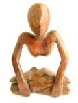 Tropical wooden yogi man in yoga sitting position cross its legs and holding both and on its knees