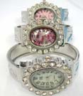 Oval shaped clock with cz gems inlaid in filigree style frame, held by floral decor bangle bracelet 