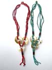 Three sea shell circle ornaments hanging from multi string beaded necklace