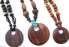 Wooden circular pendant dangling from a variety of shapes and size beaded necklace 