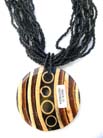 Exotic decor on wooden circle pendant hanging from multi black beaded necklace 