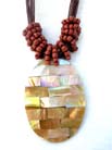 Iridescent oval pendant on multi string necklace with twisted red beads at base 