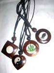 Artist made, wooden pendant with ivory colored center design on black cord necklace